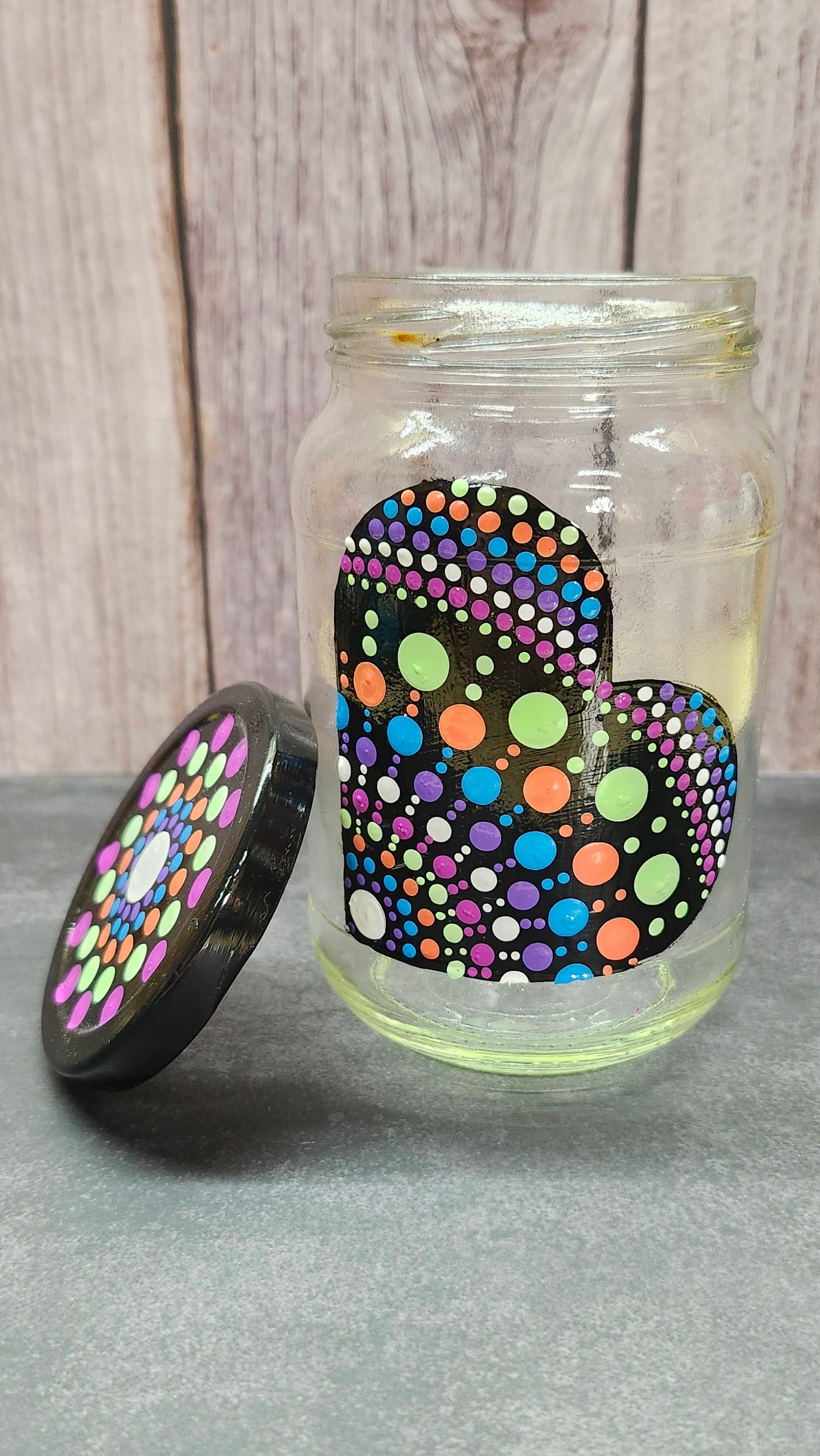 Colorful polka dot objects glass jar on a wooden surface
